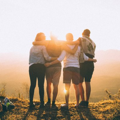 Un groupe de quatre amis de dos face à la nature, sereins après un accompagnement avec Emmanuelle Berteloot.